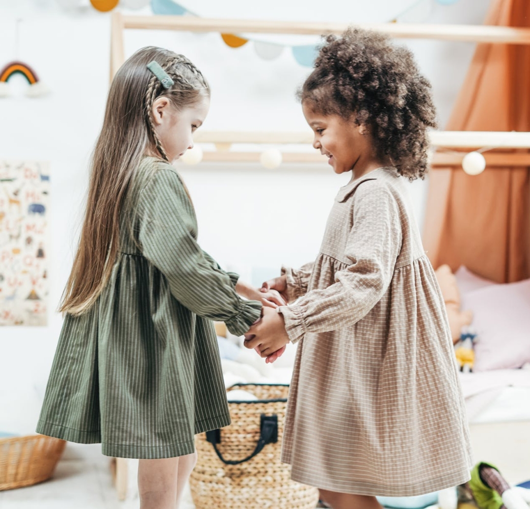 photo of girls wearing dress while holding hands